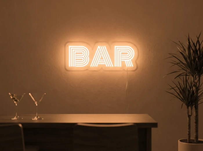 Neonskylt «BAR» i orange LED-neon, monterad på vägg