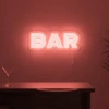 Neonskylt «BAR» i röd LED-neon, monterad på vägg