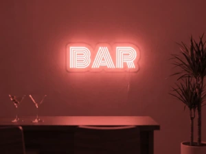 Neonskylt «BAR» i röd LED-neon, monterad på vägg