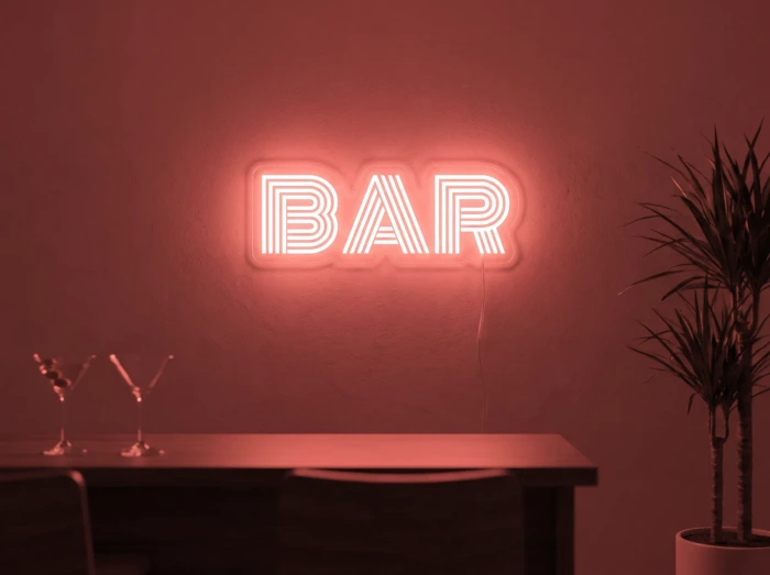Neonskylt «BAR» i röd LED-neon, monterad på vägg
