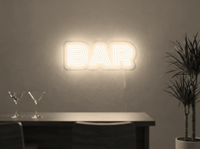 Neonskylt «BAR» i varmvit LED-neon, monterad på vägg