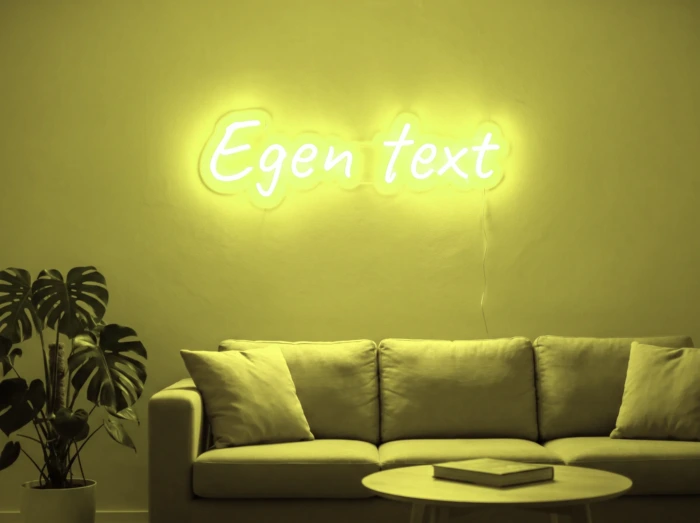 Neonskylt «Egen text» i gul LED-neon, monterad på vägg