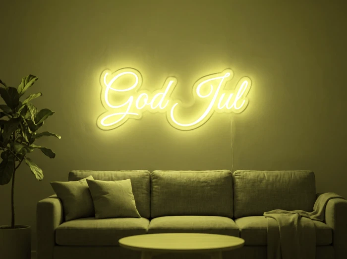Neonskylt «God Jul» i gul LED-neon, monterad på vägg