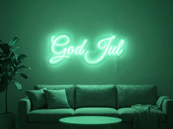 Neonskylt «God Jul» i mintgrön LED-neon, monterad på vägg