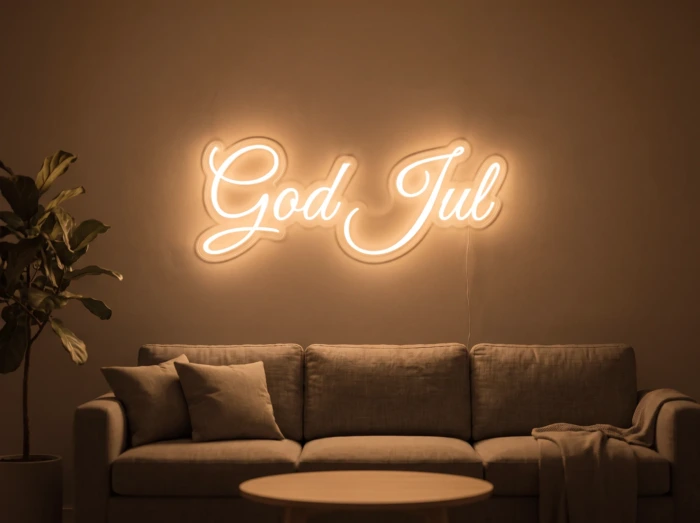 Neonskylt «God Jul» i orange LED-neon, monterad på vägg