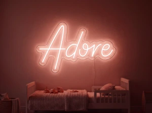 Neonskylt «Adore» i röd LED-neon, monterad på vägg