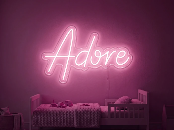 Neonskylt «Adore» i rosa LED-neon, monterad på vägg