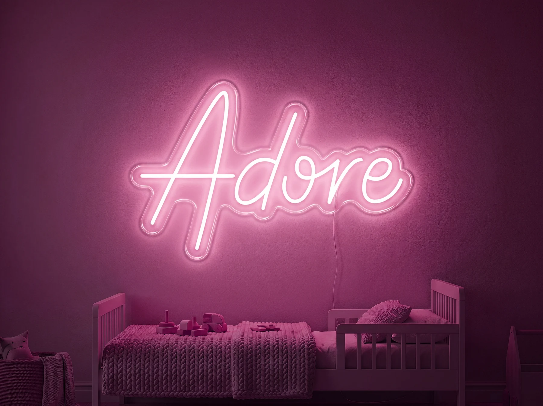 Neonskylt «Adore» i rosa LED-neon, monterad på vägg