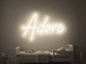 Neonskylt «Adore» i varmvit LED-neon, monterad på vägg