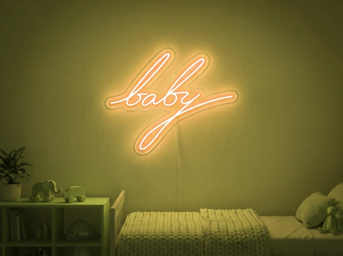 Neonskylt «Baby» i gul LED-neon, monterad på vägg