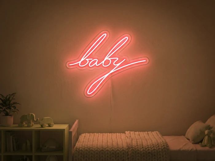 Neonskylt «Baby» i orange LED-neon, monterad på vägg