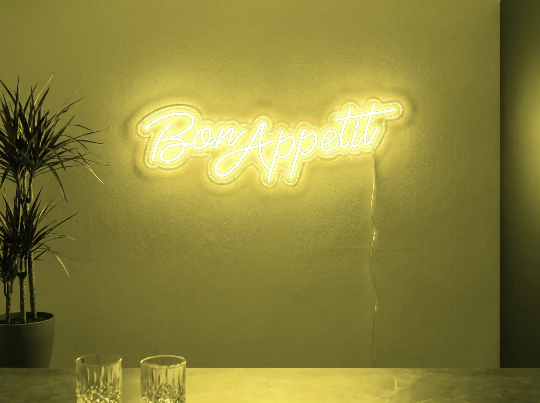 Neonskylt «Bon Appétit» i gul LED-neon, monterad på vägg