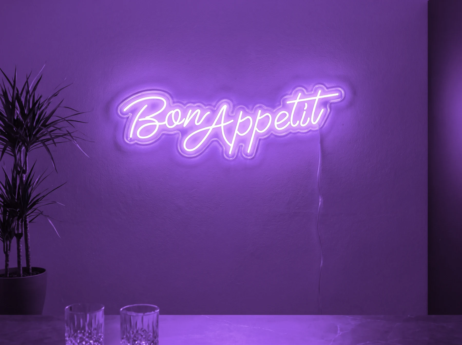 Neonskylt «Bon Appétit» i lila LED-neon, monterad på vägg