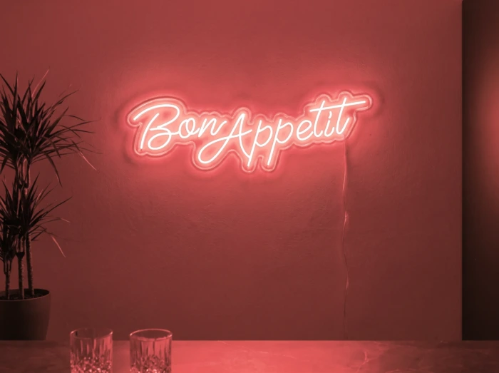 Neonskylt «Bon Appétit» i röd LED-neon, monterad på vägg