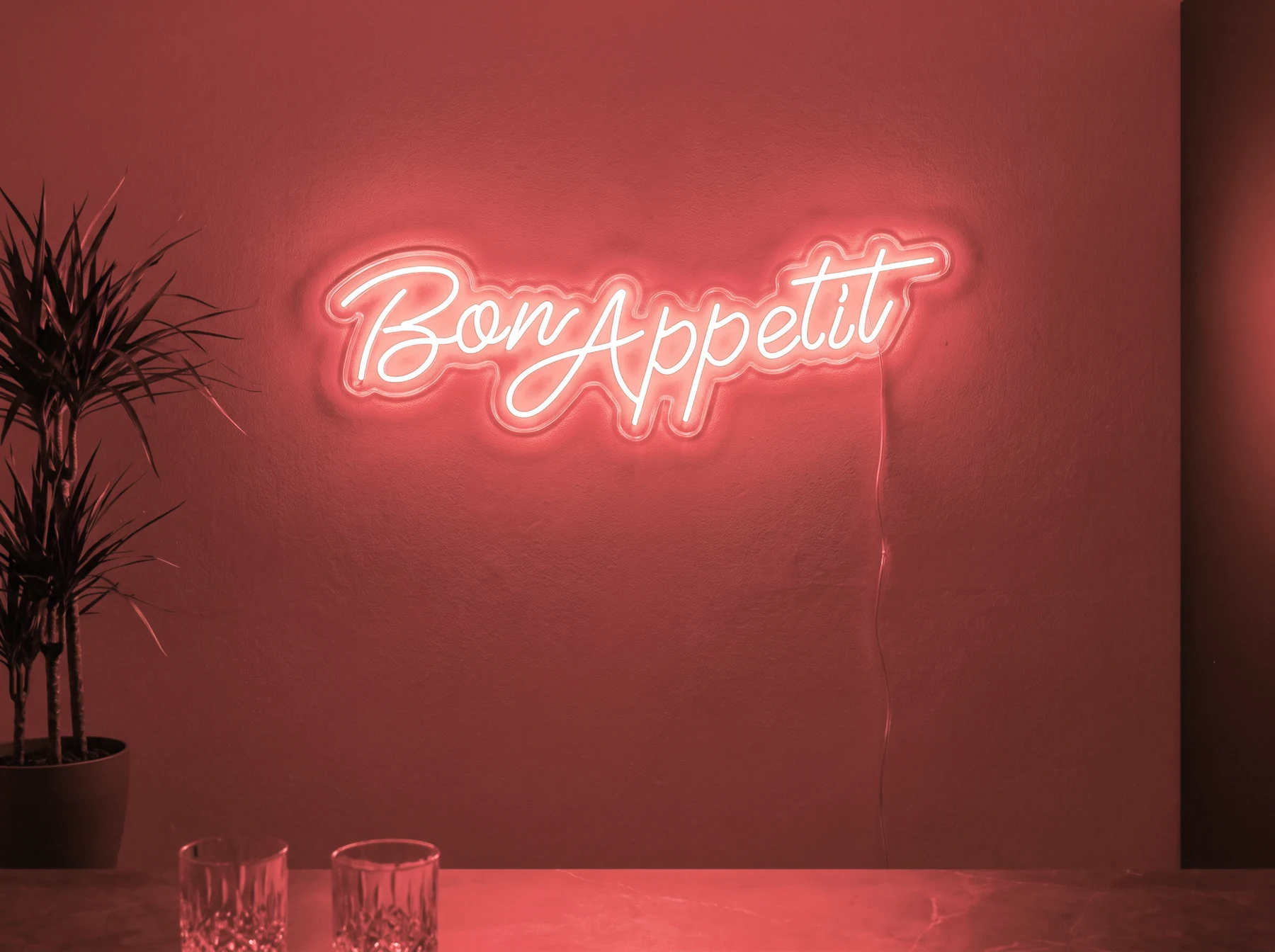 Neonskylt «Bon Appétit» i röd LED-neon, monterad på vägg