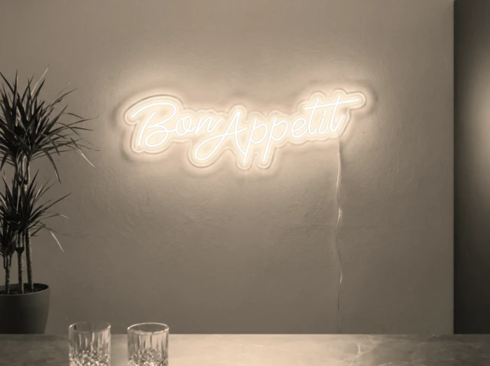Neonskylt «Bon Appétit» i varmvit LED-neon, monterad på vägg