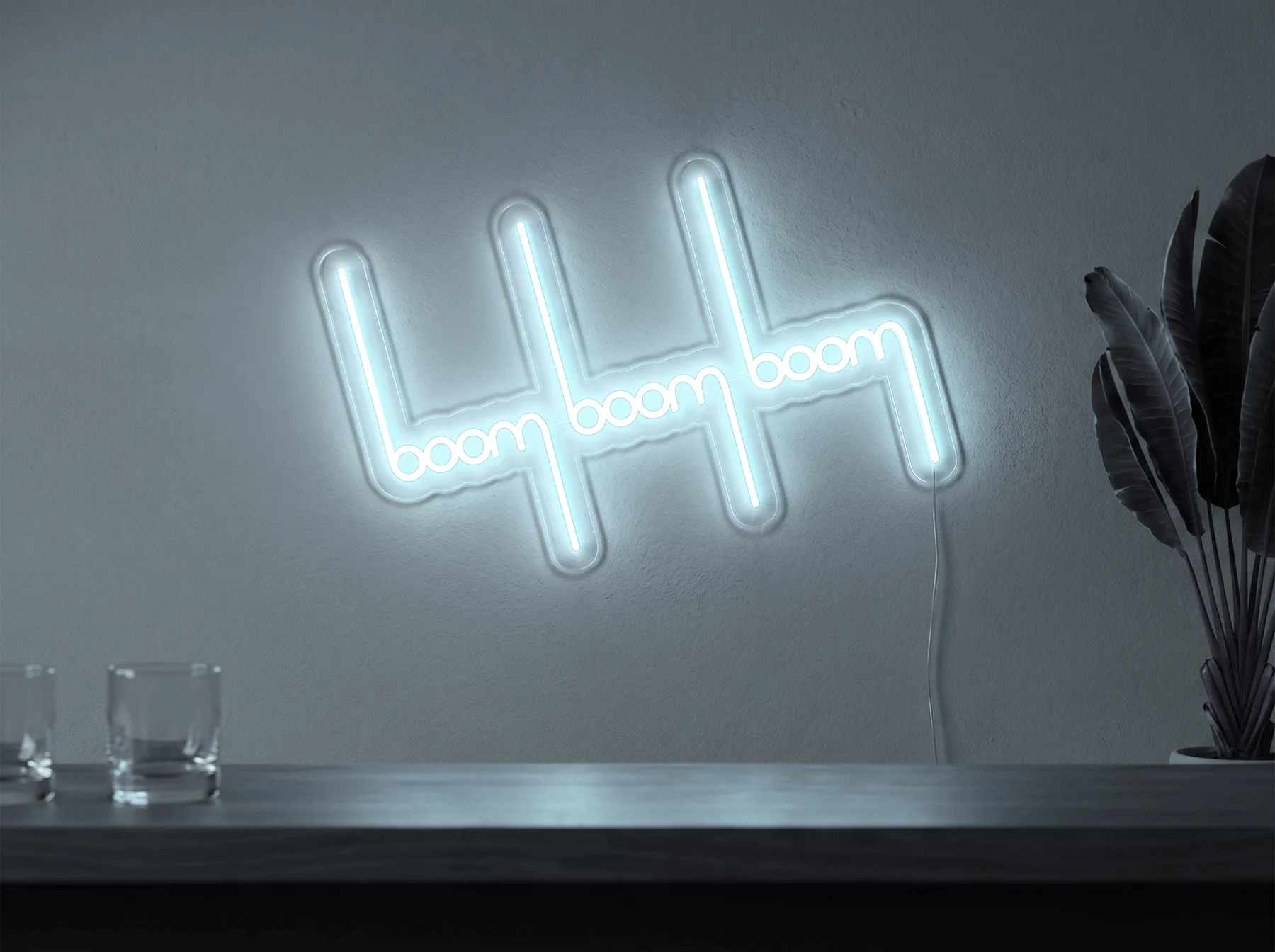 Neonskylt «Boom Boom Boom» i iskall vit LED-neon, monterad på vägg