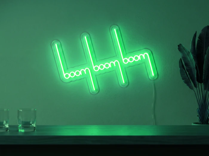 Neonskylt «Boom Boom Boom» i mintgrön LED-neon, monterad på vägg