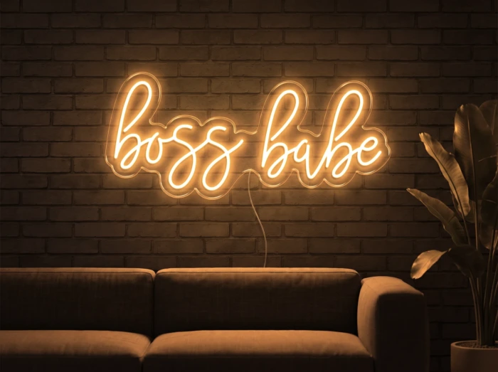 Neonskylt «Boss Babe» i orange LED-neon, monterad på vägg