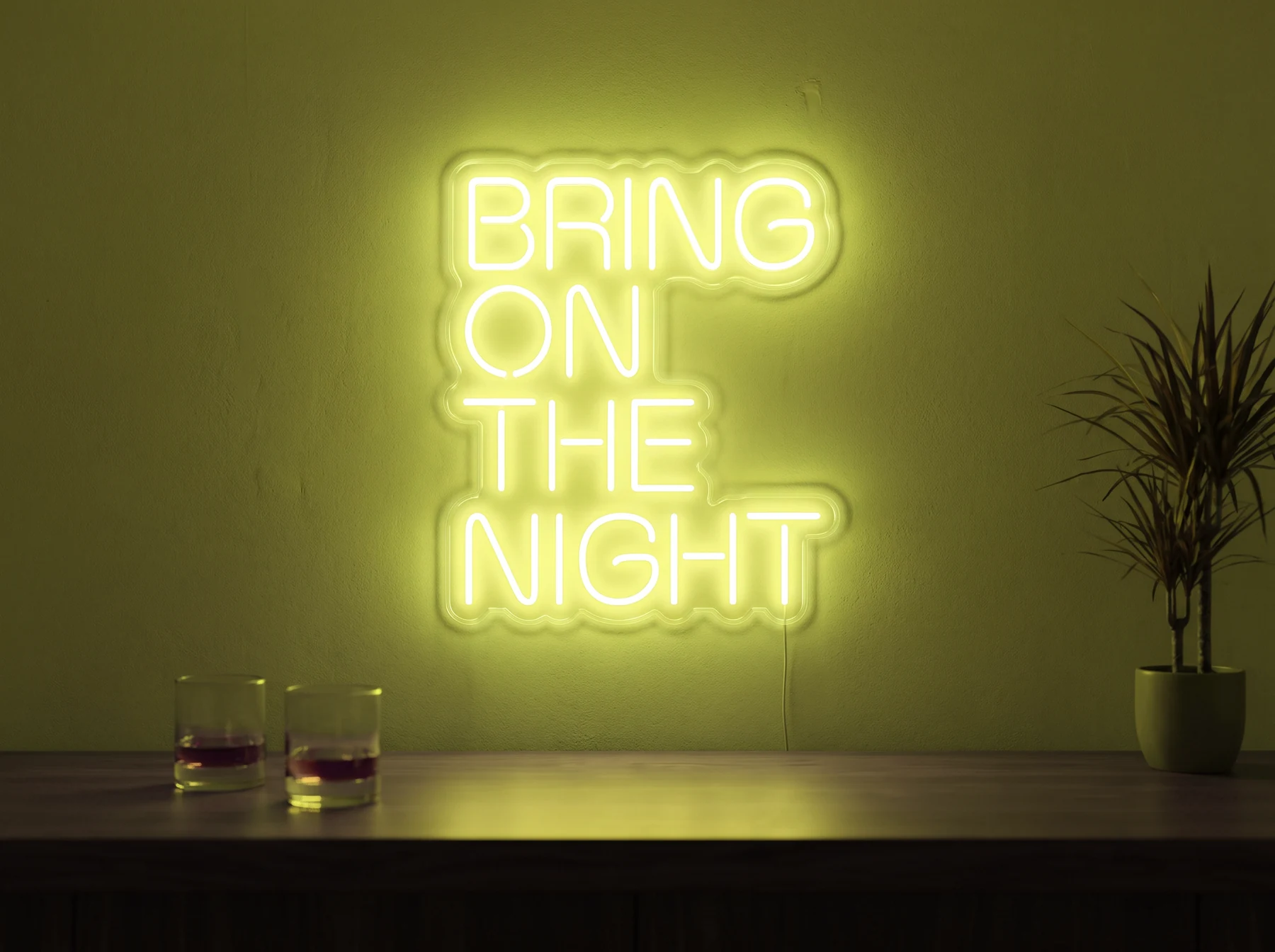 Neonskylt «Bring On The Night» i gul LED-neon, monterad på vägg