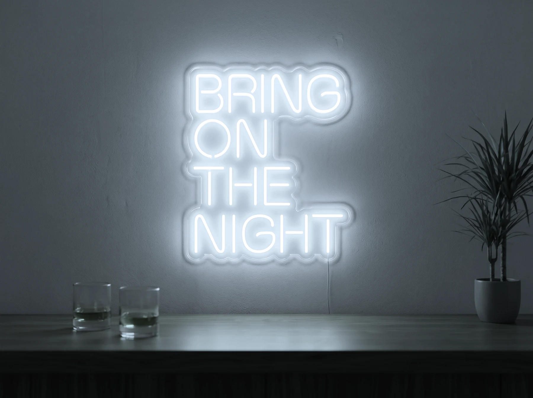 Neonskylt «Bring On The Night» i iskall vit LED-neon, monterad på vägg