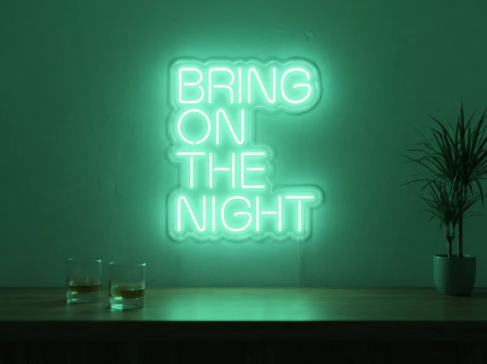 Neonskylt «Bring On The Night» i mintgrön LED-neon, monterad på vägg