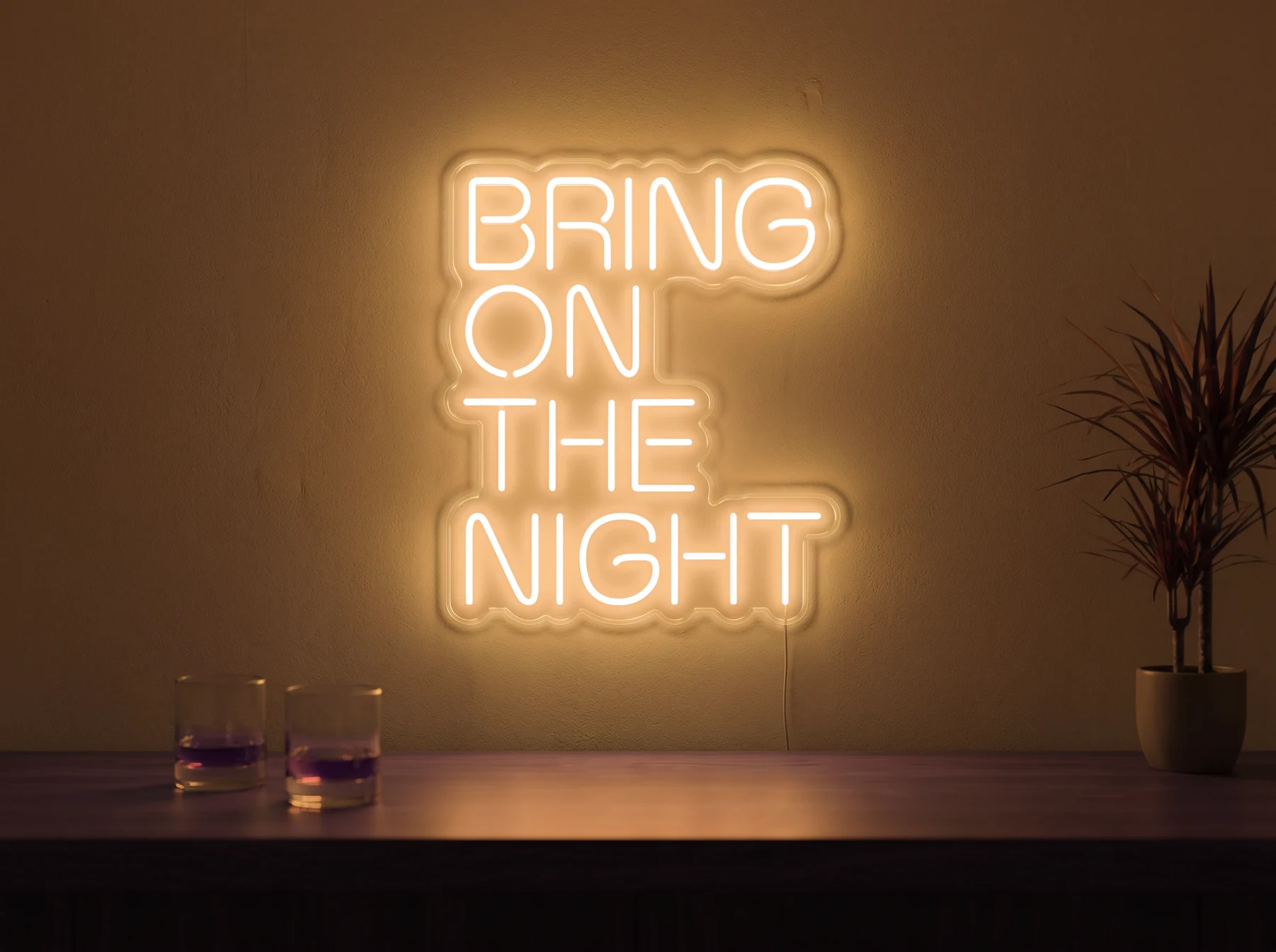 Neonskylt «Bring On The Night» i orange LED-neon, monterad på vägg