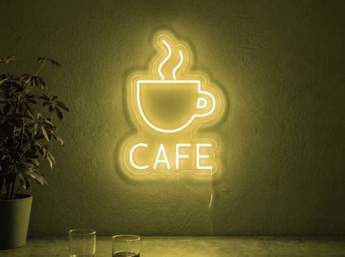 Neonskylt «Cafe» i gul LED-neon, monterad på vägg