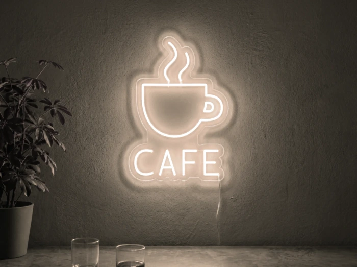 Neonskylt «Cafe» i varmvit LED-neon, monterad på vägg