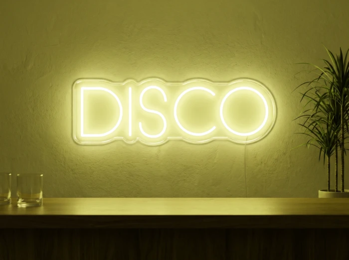 Neonskylt «Disco» i gul LED-neon, monterad på vägg