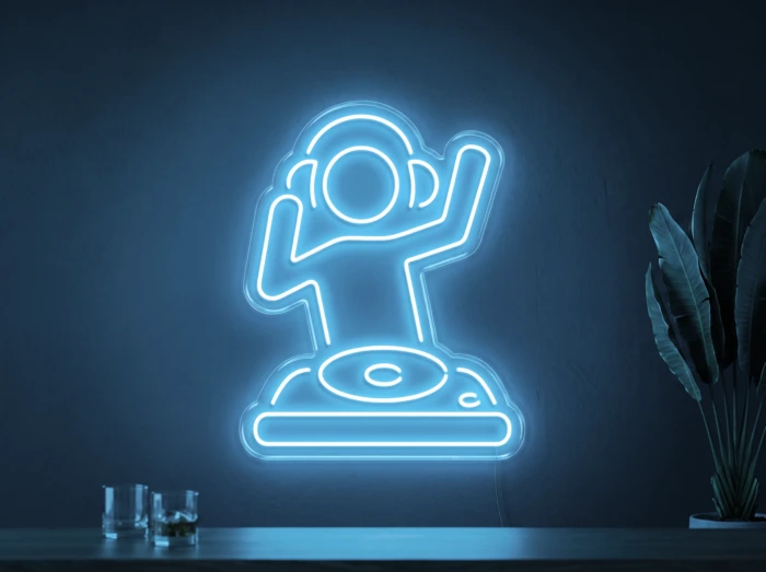 Neonskylt «DJ» i isblå LED-neon, monterad på vägg