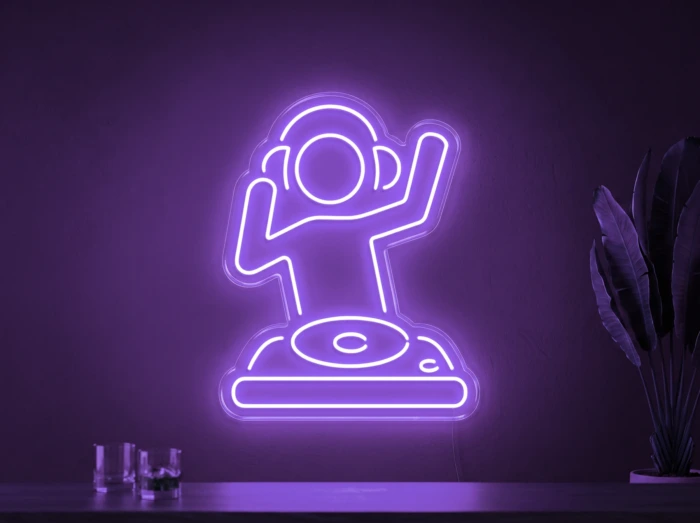 Neonskylt «DJ» i lila LED-neon, monterad på vägg