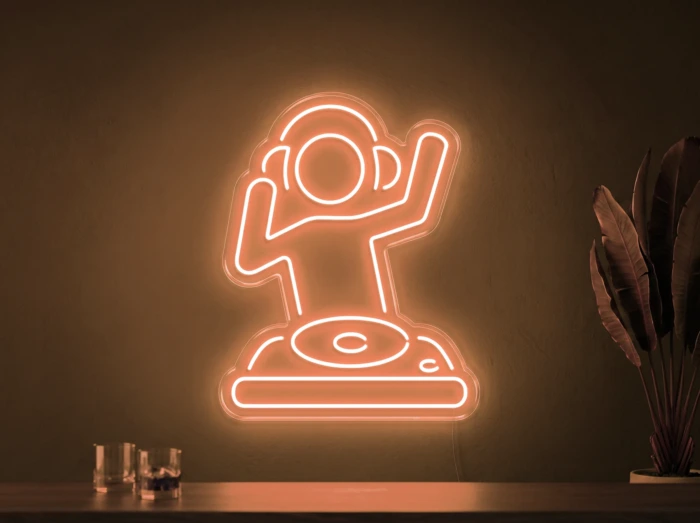 Neonskylt «DJ» i orange LED-neon, monterad på vägg