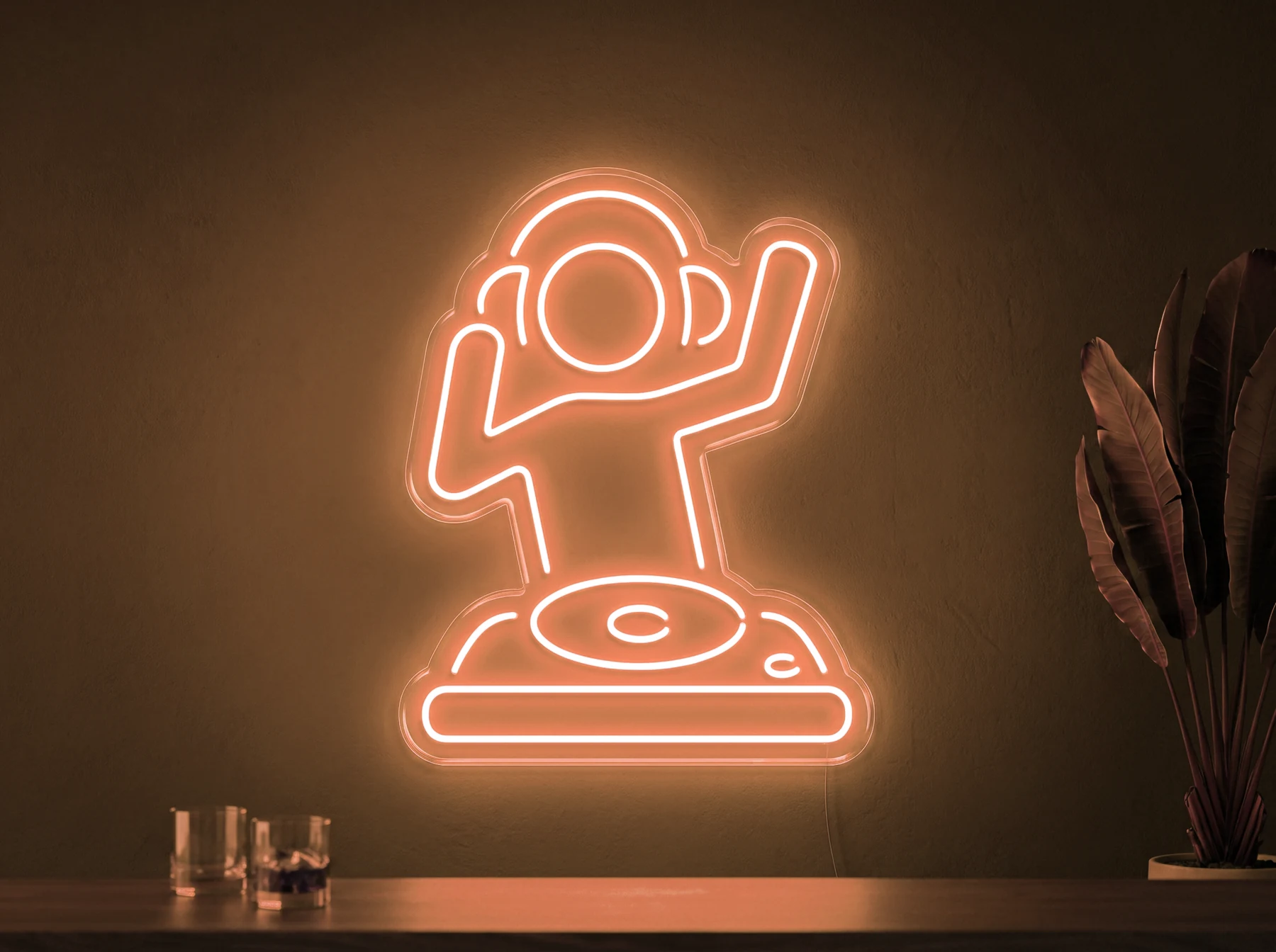 Neonskylt «DJ» i orange LED-neon, monterad på vägg
