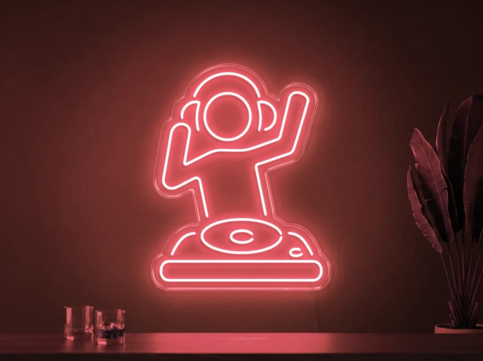 Neonskylt «DJ» i röd LED-neon, monterad på vägg