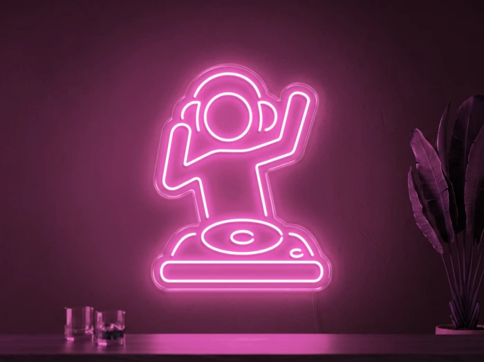 Neonskylt «DJ» i rosa LED-neon, monterad på vägg