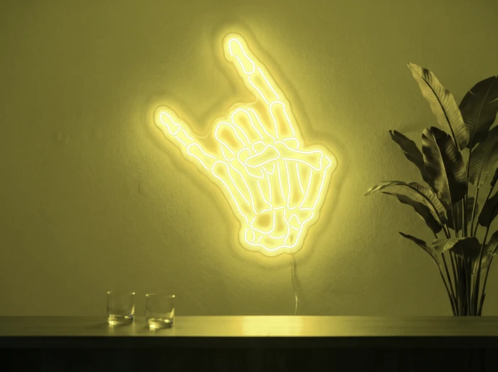Neonskylt «Dödskalle» i gul LED-neon, monterad på vägg