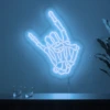 Neonskylt «Dödskalle» i isblå LED-neon, monterad på vägg