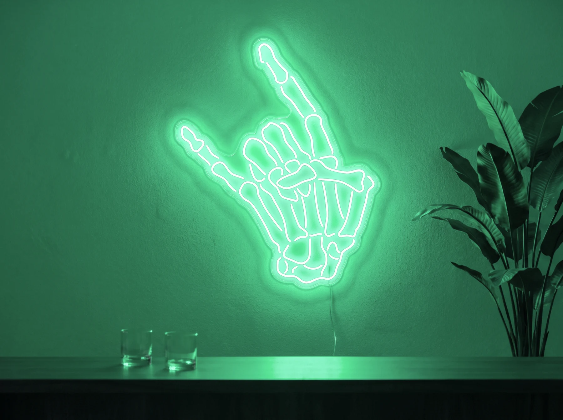 Neonskylt «Dödskalle» i mintgrön LED-neon, monterad på vägg
