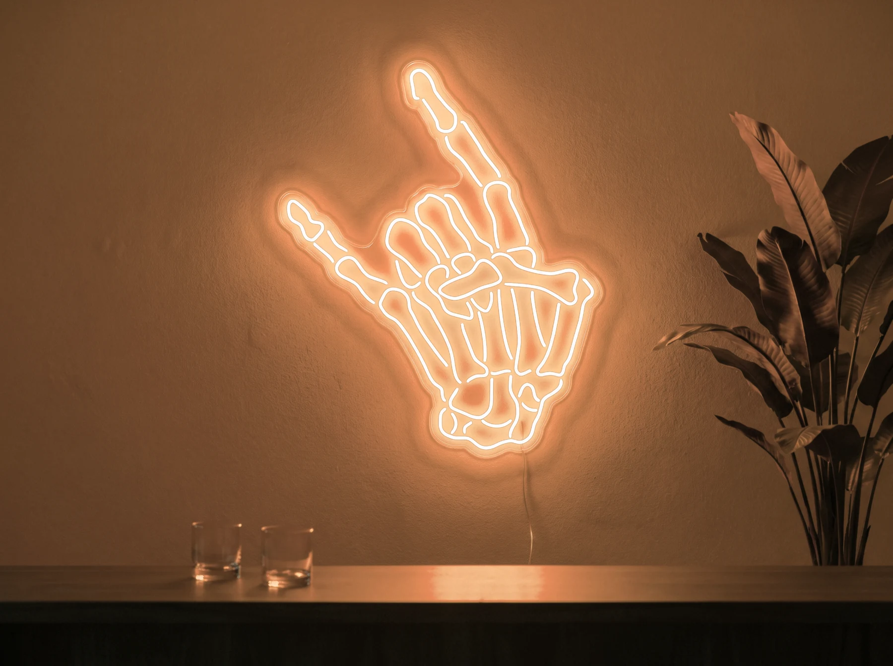 Neonskylt «Dödskalle» i orange LED-neon, monterad på vägg