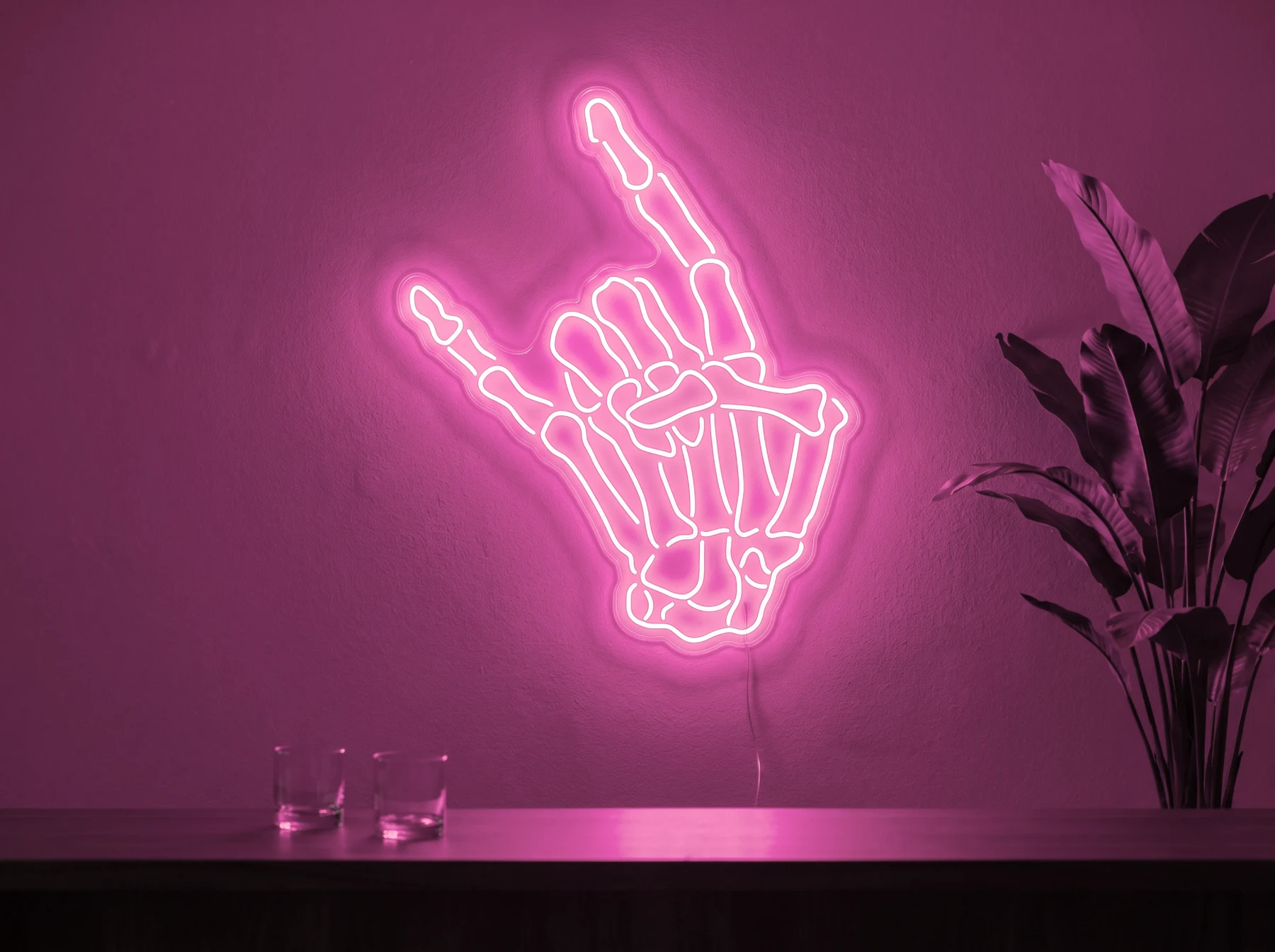Neonskylt «Dödskalle» i rosa LED-neon, monterad på vägg