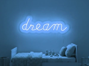 Neonskylt «Dream» i isblå LED-neon, monterad på vägg