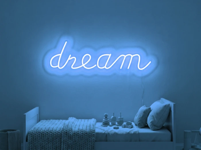 Neonskylt «Dream» i isblå LED-neon, monterad på vägg