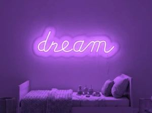 Neonskylt «Dream» i lila LED-neon, monterad på vägg