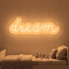 Neonskylt «Dream» i orange LED-neon, monterad på vägg