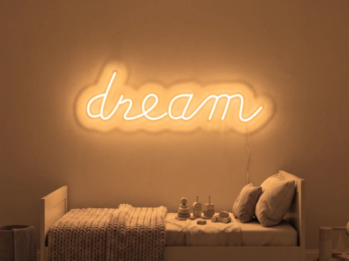 Neonskylt «Dream» i orange LED-neon, monterad på vägg