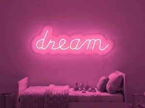 Neonskylt «Dream» i rosa LED-neon, monterad på vägg