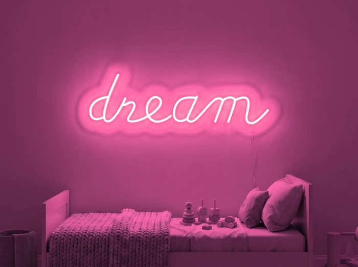 Neonskylt «Dream» i rosa LED-neon, monterad på vägg