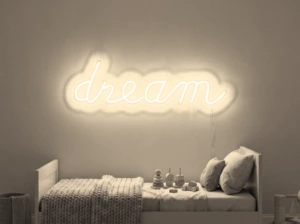 Neonskylt «Dream» i varmvit LED-neon, monterad på vägg