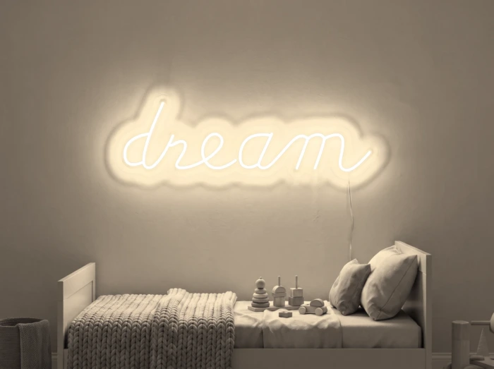Neonskylt «Dream» i varmvit LED-neon, monterad på vägg